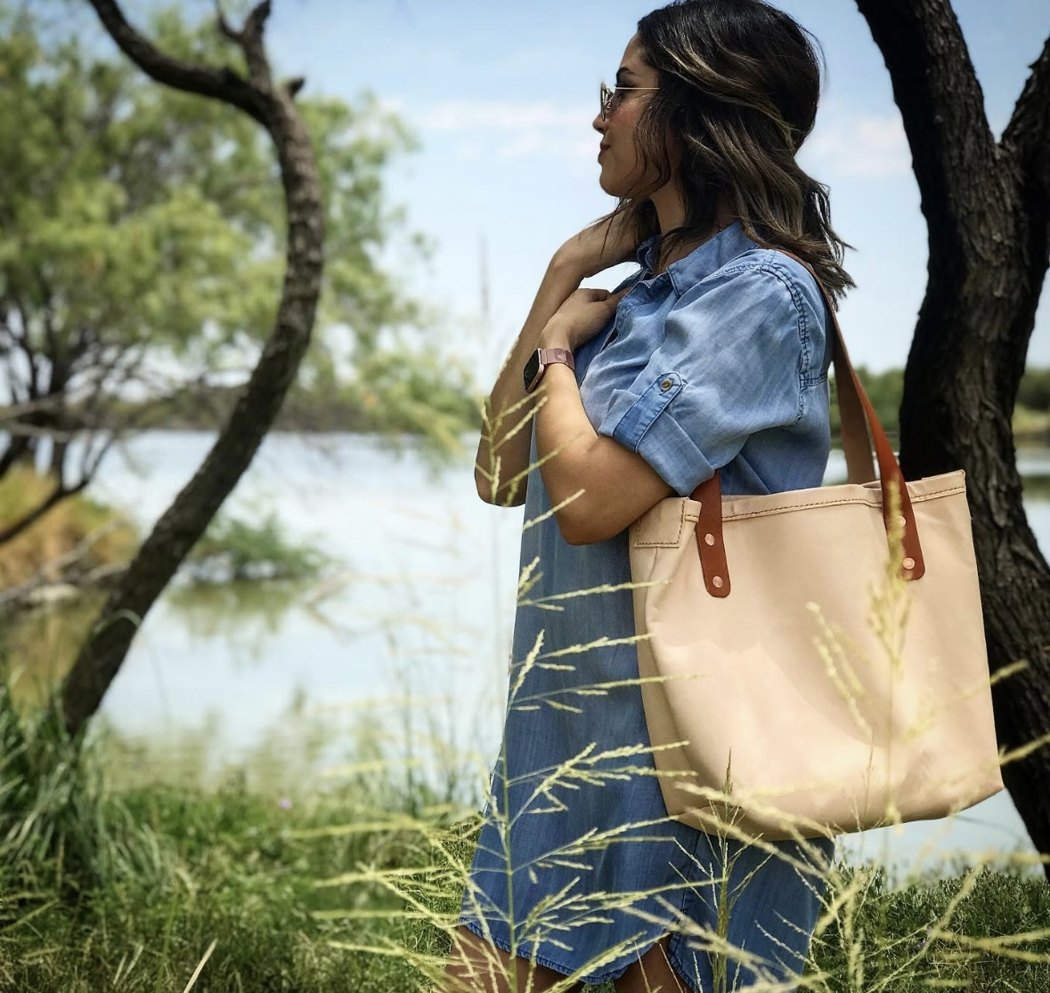 La esposa de Frank cargando una bolsa de cuero que él hizo, junto al lago